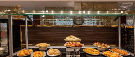 A buffet with various dishes and a decorative glass canopy.