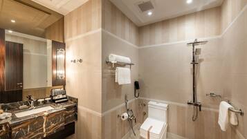 A modern bathroom with a marble sink, a toilet, and a shower.
