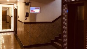 A hotel lobby with a reception desk, a digital screen, and a staircase. - Hotel Empark (Bengaluru)
