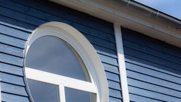 Een gebouw met een rond raam en horizontale gevelbekleding.