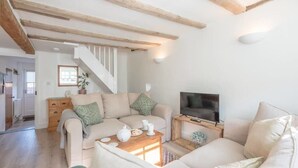 A cozy living room with a sofa set, a television, and a wooden coffee table. - Candy Cottage, Halesworth (Halesworth)