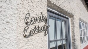 A building with a textured white exterior and a window with a metal sign that reads "Candy Cottage." - Candy Cottage, Halesworth (Halesworth)