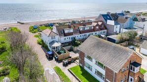 A coastal residential area with houses, a beach, and a clear view of the sea.