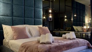 A modern hotel room with a large bed, a tufted headboard, and a mirror reflecting the room. - The Lion Rooms (Zadar)