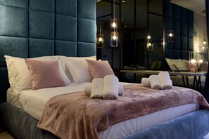 A modern hotel room with a large bed, a tufted headboard, and a mirror reflecting the room. - The Lion Rooms (Zadar)