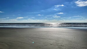 A beach with a clear sky and sunlight reflecting on the water. - Island life, Island time, After Dune Delight (Freeport)