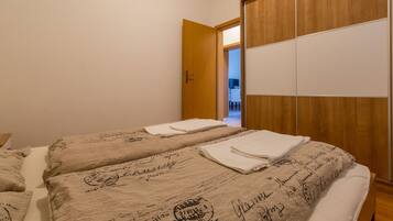 Ein Hotelzimmer mit zwei Betten, einem Holzschrank und einer Tür zu einem Badezimmer.