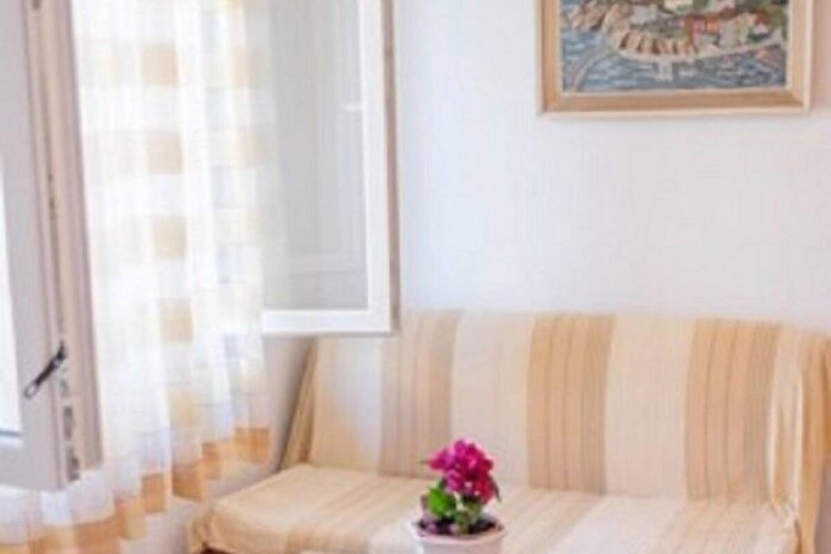 A cozy living room with a striped sofa, a wooden coffee table, and a painting on the wall.