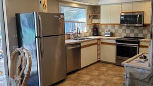 A compact kitchen with a refrigerator, microwave, stove, and sink. - Minutes to gulf beaches, great outdoor space, putting green,perfect getaway  (Englewood)