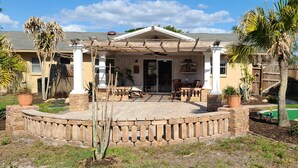 A covered patio area with a brick border, outdoor furniture, and a pool. - Minutes to gulf beaches, great outdoor space, putting green,perfect getaway  (Englewood)