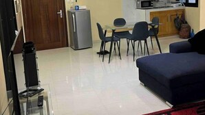 Un espace de vie compact comprenant un coin repas, une kitchenette et un coin salon avec un canapé.