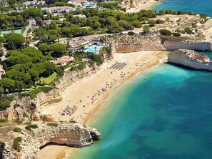 A coastal area with a beach, cliffs, and a pool area surrounded by greenery. - Bryonia Apartment, Balcony, Pool! New! (Porches)