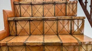 Una escalera con baldosas de terracota y barandillas de madera.