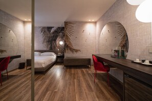 Relax in a stylish room with a comfortable sofa, neatly made bed, and a desk area for work.