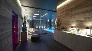 A modern interior with wooden panel walls, a glass partition, and a reception area with a counter and decorative items. - Phi Hotel Piajo (Nembro)