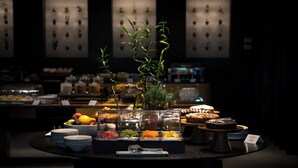 A buffet with various food items and a decorative plant in the center. - Phi Hotel Piajo (Nembro)