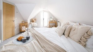 Une chambre confortable avec un grand lit, une table de chevet et une fenêtre.