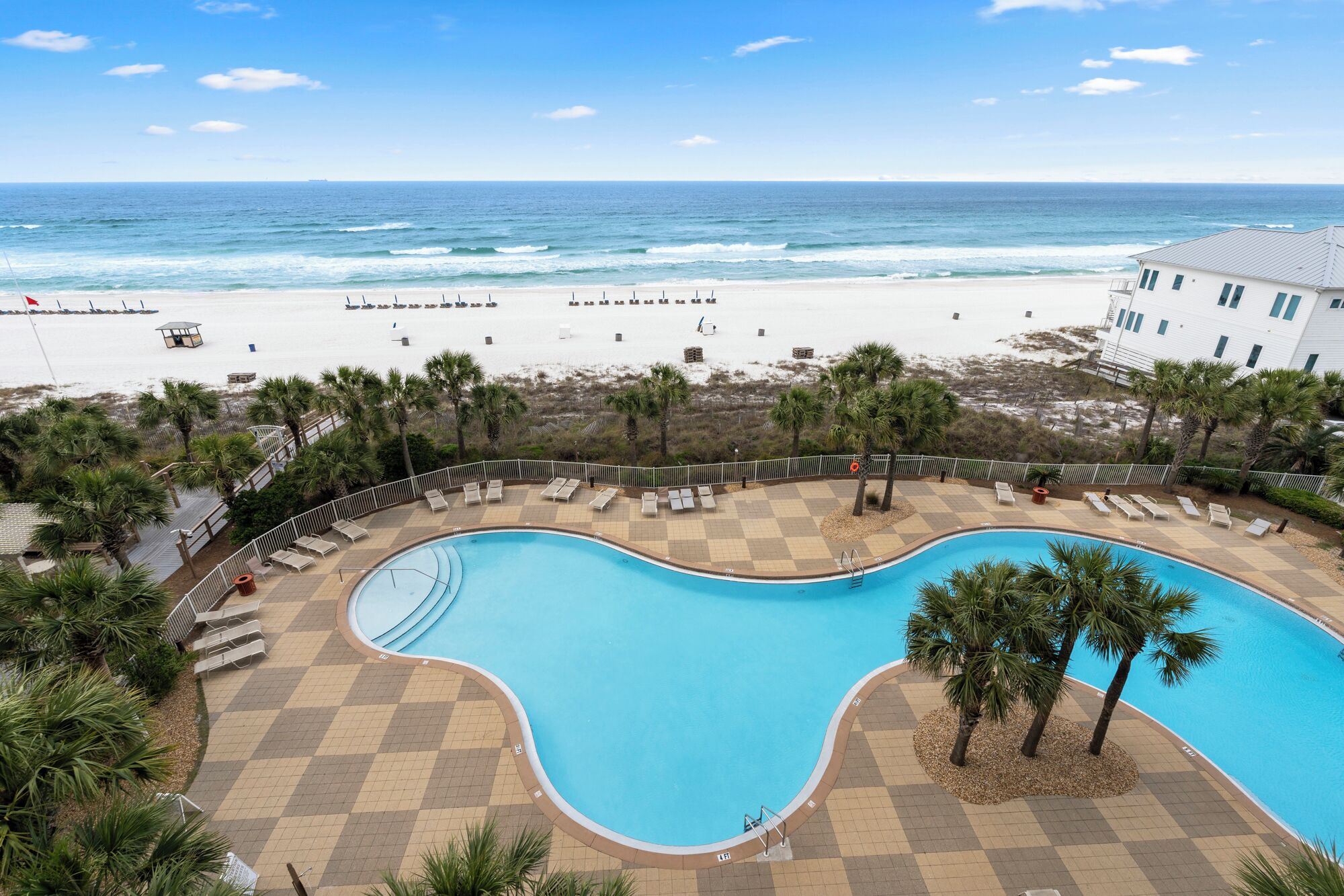 Un espace piscine offrant une vue sur la plage et l’océan.