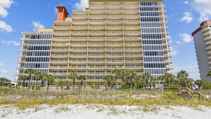 Un hotel de diverses plantes amb façana uniforme, balcons i vista a la platja.