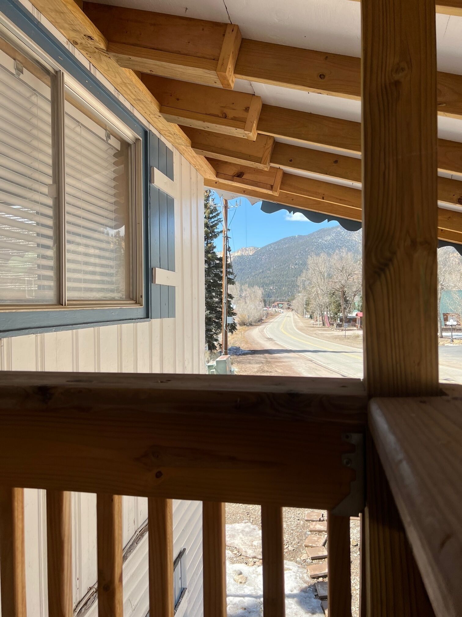 Una terraza de madera con vistas a una carretera y montañas.