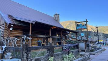 Eine rustikale Holzhütte mit Metall-Dach und einer Holzveranda, mit einem Schild für 'NOLS Water Winery & Cellars'.