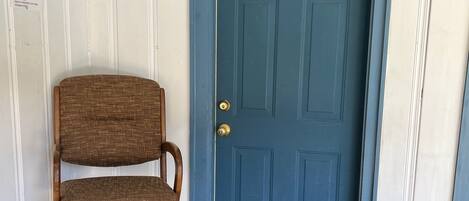 A blue door with a doormat that reads "WELCOME" and a bear design.