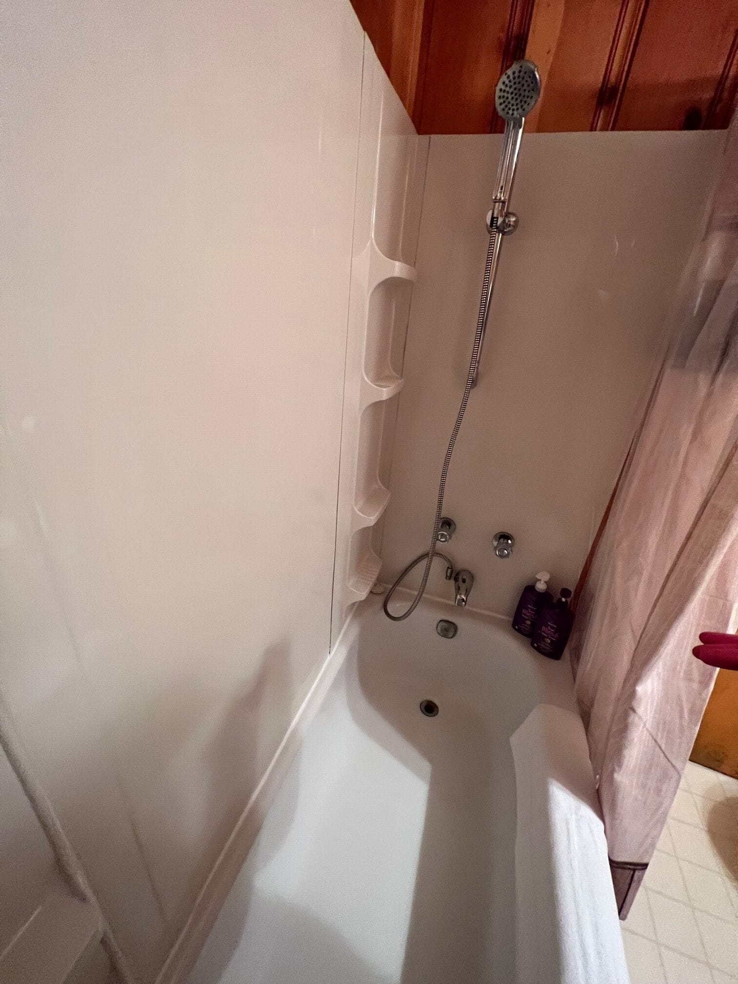 A bathroom with a bathtub, shower, and a toilet.