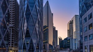 A cityscape with modern high-rise buildings, including a distinctive building with a diamond-shaped facade. - Superbe appart de 129m2, 3 ch-Neuilly 2 min Paris (Neuilly-sur-Seine)
