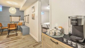 A modern room with a kitchenette, a coffee maker, and a seating area with chairs and a table. - El Sereno Bungalow! Pet-Friendly Ivywild Flat (Colorado Springs)