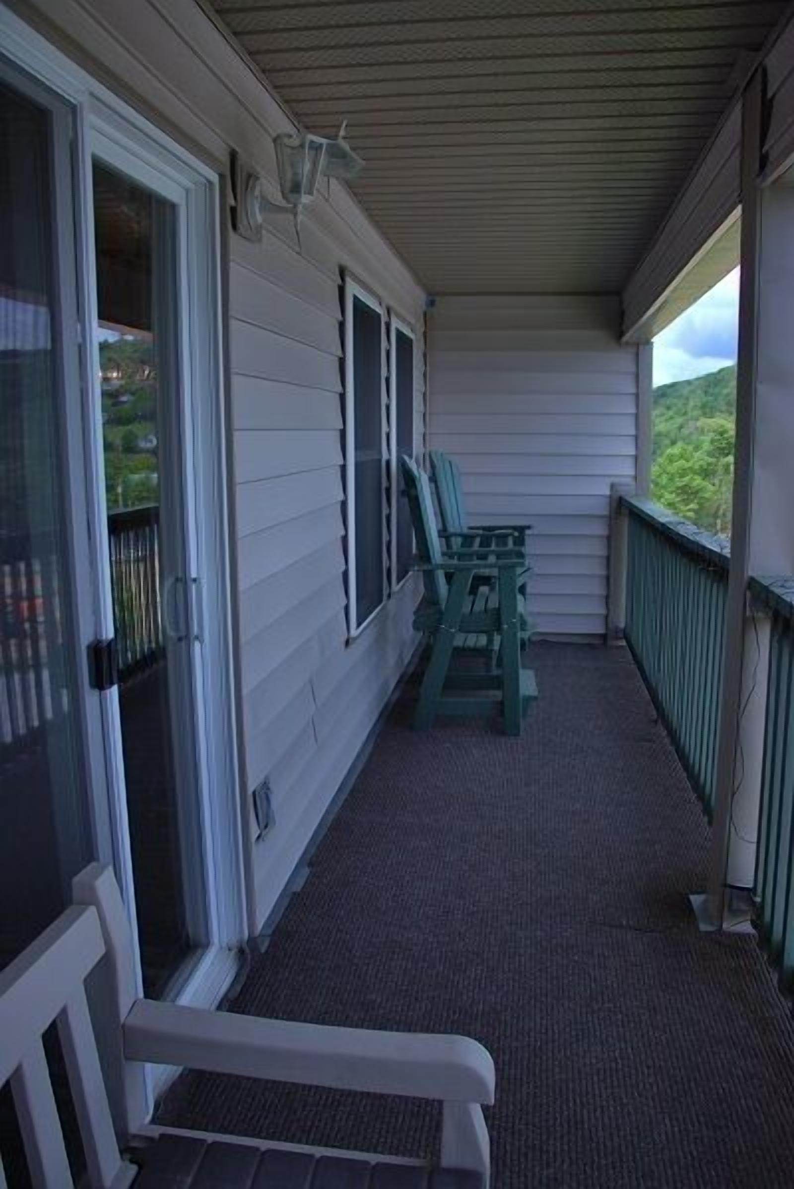A covered porch with a bench, a table, and chairs.
