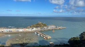 A coastal town with a prominent hill, a pier, and a marina.