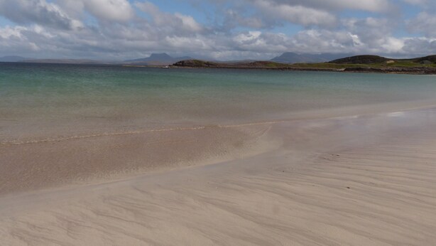 A beach with clear water, a boat, and distant hills. - Lodge 3 - Pet Friendly - Aultbea Lodges - Sea Views of Loch Ewe (Achnasheen)
