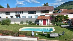 A building with a swimming pool, a red door, and a sign indicating a no swimming zone.