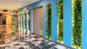 Un pasillo con pared azul y piso de mármol.