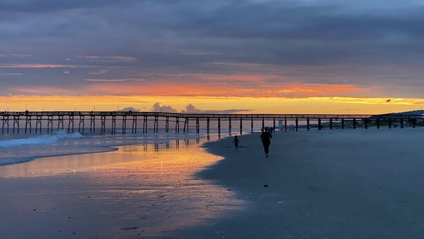 A pier extending into the water with people walking along it. - On canal. 3 minute walk from beach! 5 minutes from everything!! (Ocean Isle Beach)