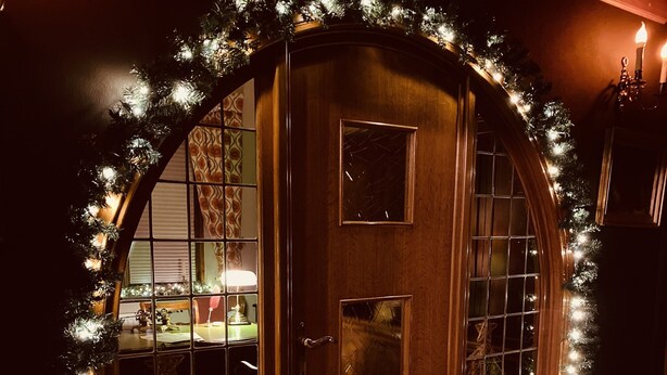A checkered floor, a wooden door with glass panels, and a Christmas tree with lights. - Potter's Place by Ardenne Places (Spa)
