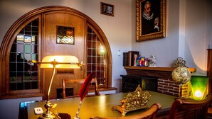 A room with a wooden desk, a lamp, a globe, and a fireplace. - Potter's Place by Ardenne Places (Spa)