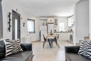 Relax in this inviting living area with a dining table, comfortable sofa, and kitchenette.