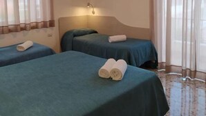 A hotel room with two beds, a large window with sheer curtains, and a hanging light fixture. - Hotel Maria (Castellabate)