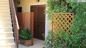 A multi-level building with a staircase, potted plants, and a balcony with decorative railings. - Hotel Maria (Castellabate)
