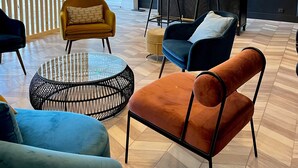 A modern lounge area with a bar, seating arrangements, and a decorative partition. - Hôtel Restaurant du Lac (Boussens)