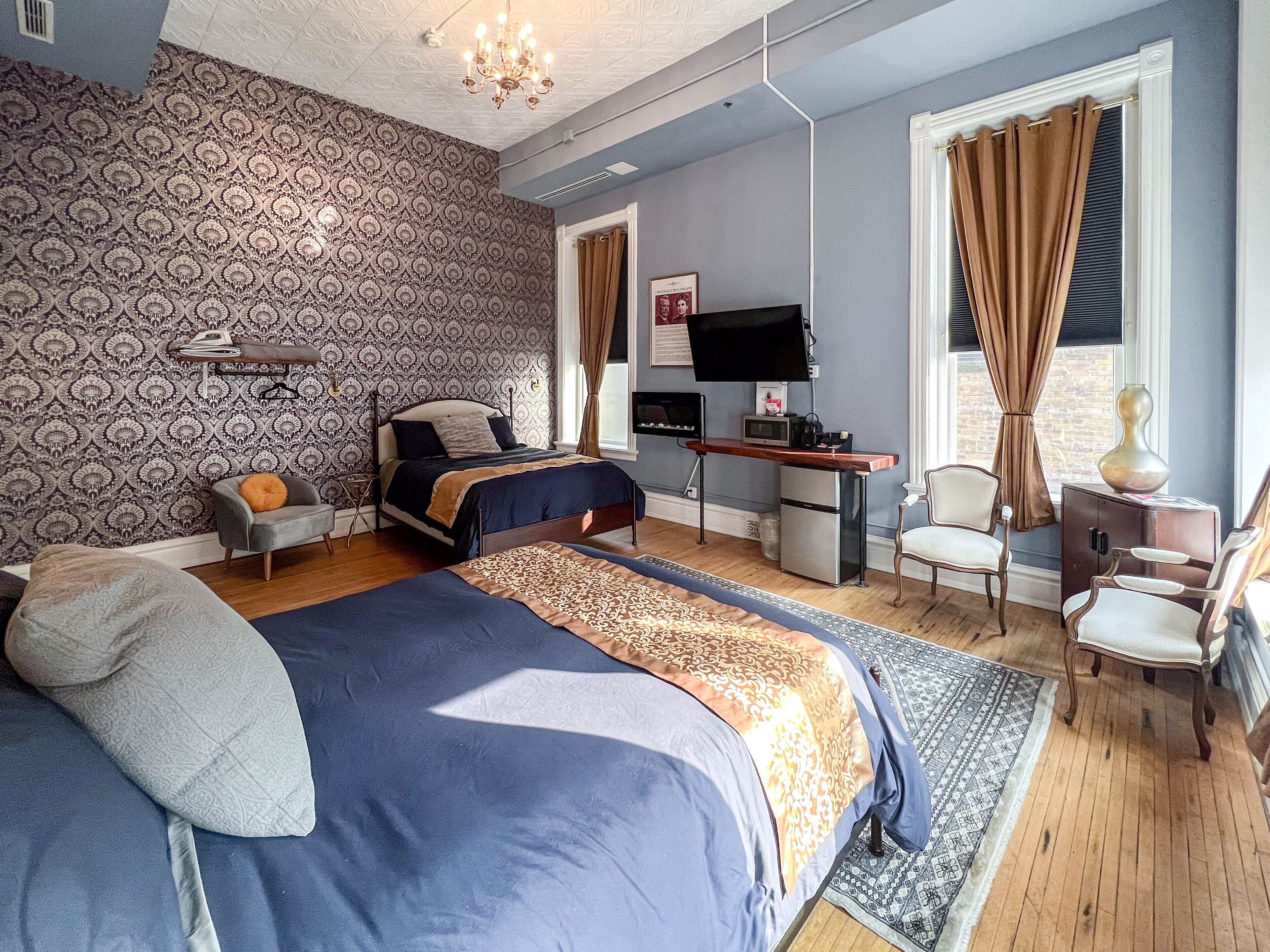Un dormitorio con cama, escritorio, televisión y silla.