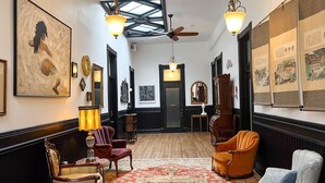 A spacious lobby with a high ceiling, a large red patterned rug, and several pieces of furniture including armchairs and a sofa. - The Oliver Inn | Duluth Hotel Near Canal Park (Duluth)