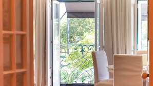 An open door leading to a balcony with a chair and a view of greenery. - Belem Prestige by Homing (Lisbon)