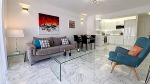 A modern living room with a sofa, coffee table, and a dining area. - N&J - FLOREAL BEACH - Central - Close sea  (Niza)