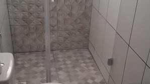 Un baño con inodoro, ducha y lavamanos.