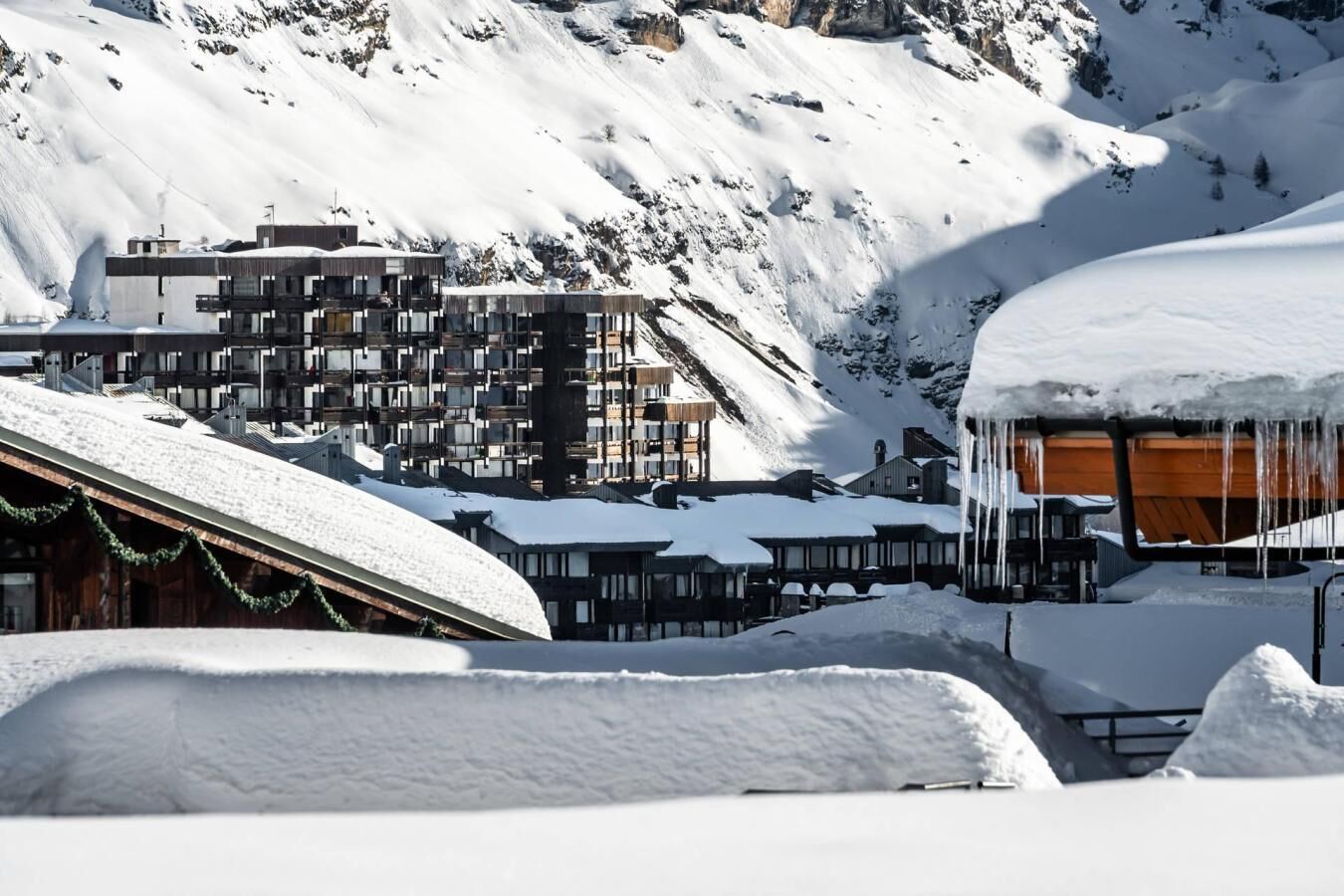 A snow-covered mountain village with modern buildings and wooden structures.