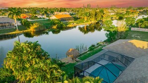 A residential area with a large body of water, houses, and a glass-enclosed building. - Waterfront Paradise with HTD Pool, Kayaks & Games (Cape Coral)