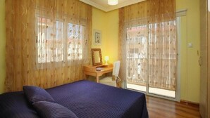 A bedroom with a bed, a desk, and a chair. - Nissi Villa Loreana (Ammochostos Ayia Napa)