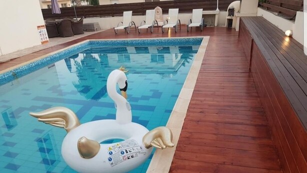 A swimming pool with a swan floatation device. - Nissi Villa Loreana (Ammochostos Ayia Napa)